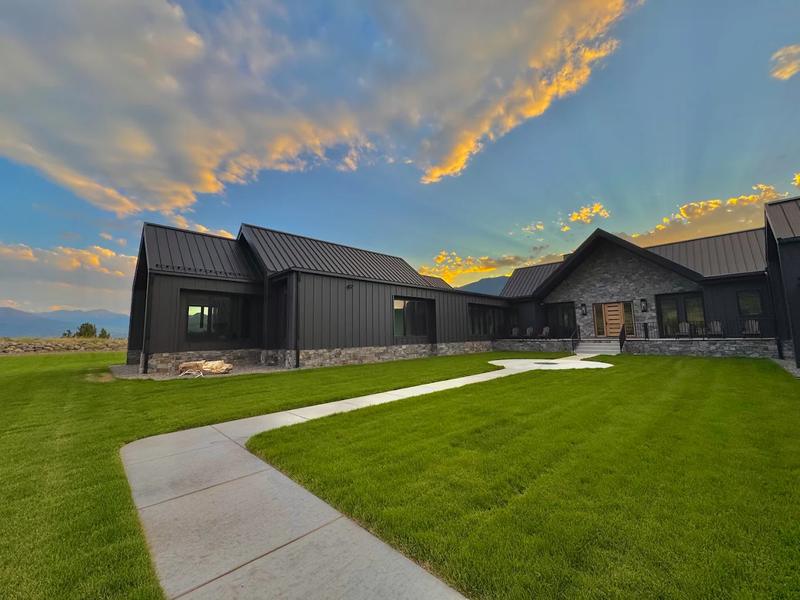 Modern mountain home at sunset with a manicured lawn