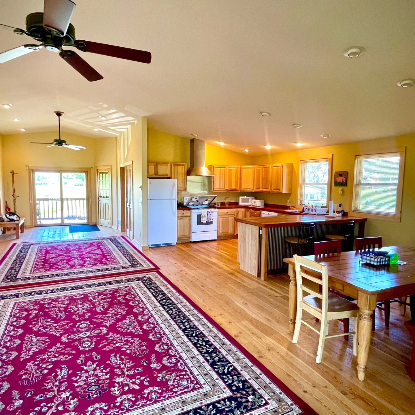 Open-plan living and kitchen with hickory cabinets and a vaulted ceiling
